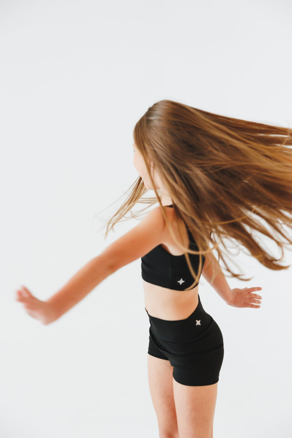 Person wearing a black outfit with star designs on a white background